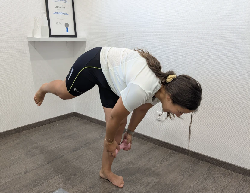 femme se penche en avant en équilibre sur un pied