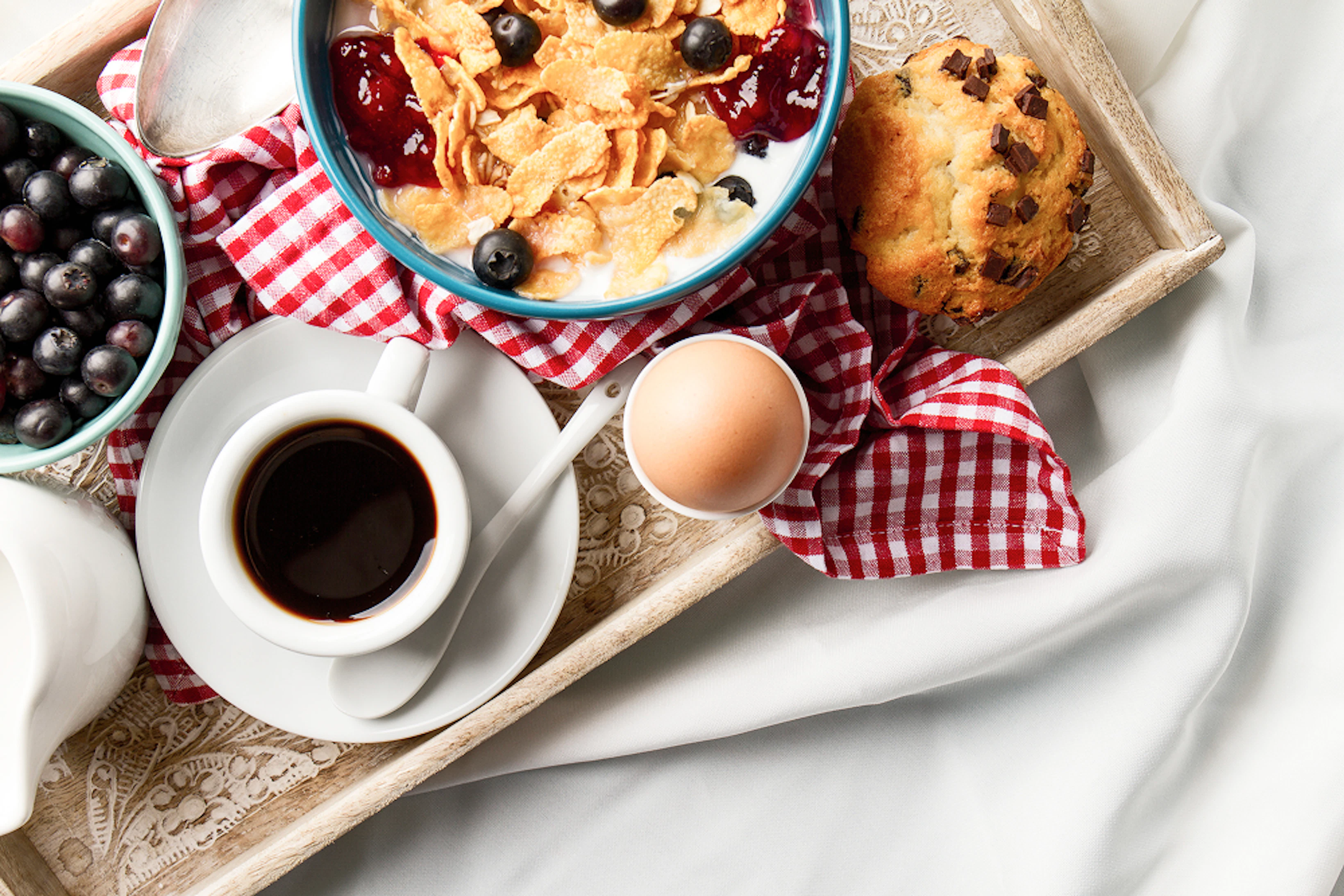 Petit-déjeuner protéiné : oeuf, céréales, yaourt, fruits rouges, confiture, muffin, café.