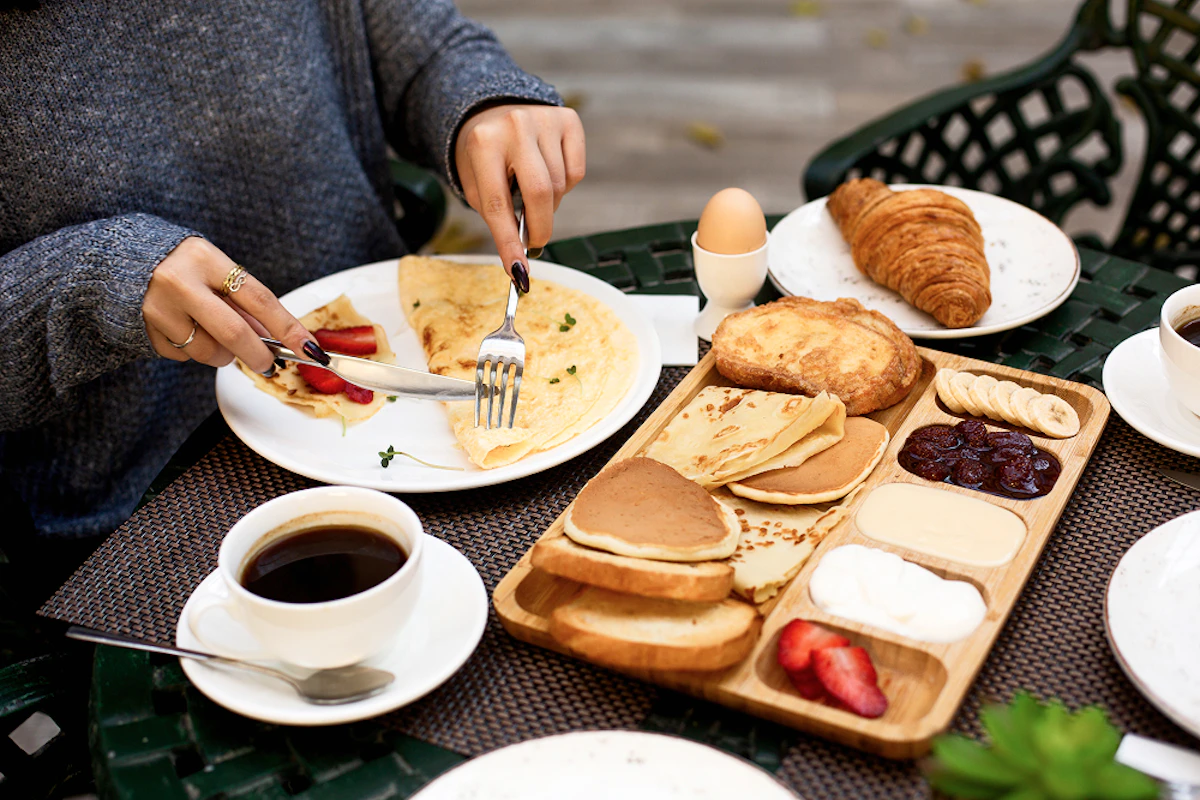 Manger des protéines le matin : crêpes, pancakes, fruits, café, oeuf, croissant.