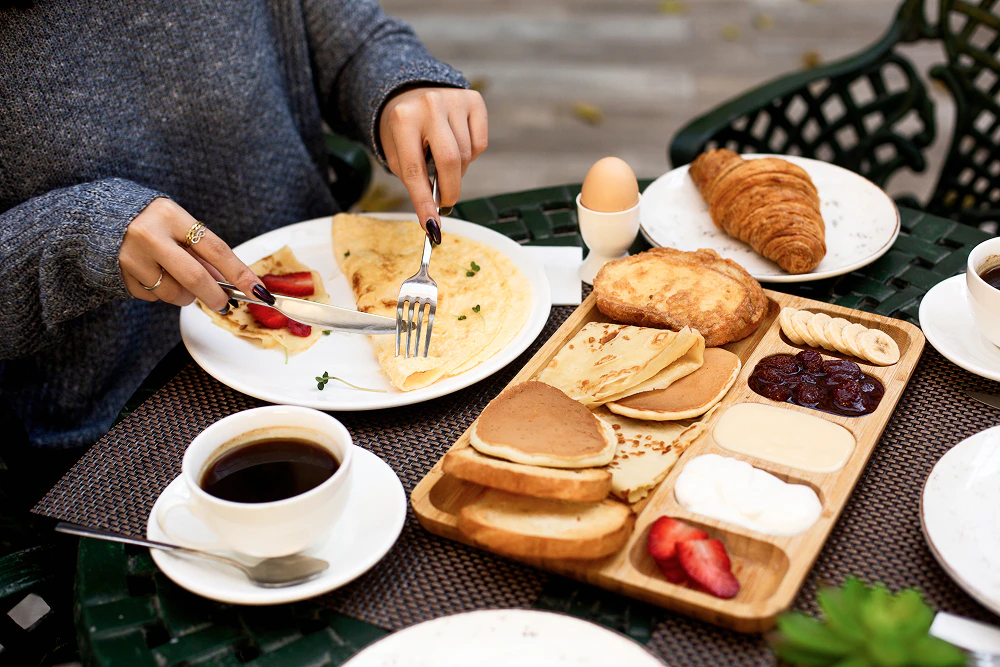 Manger des protéines le matin : crêpes, pancakes, fruits, café, oeuf, croissant.