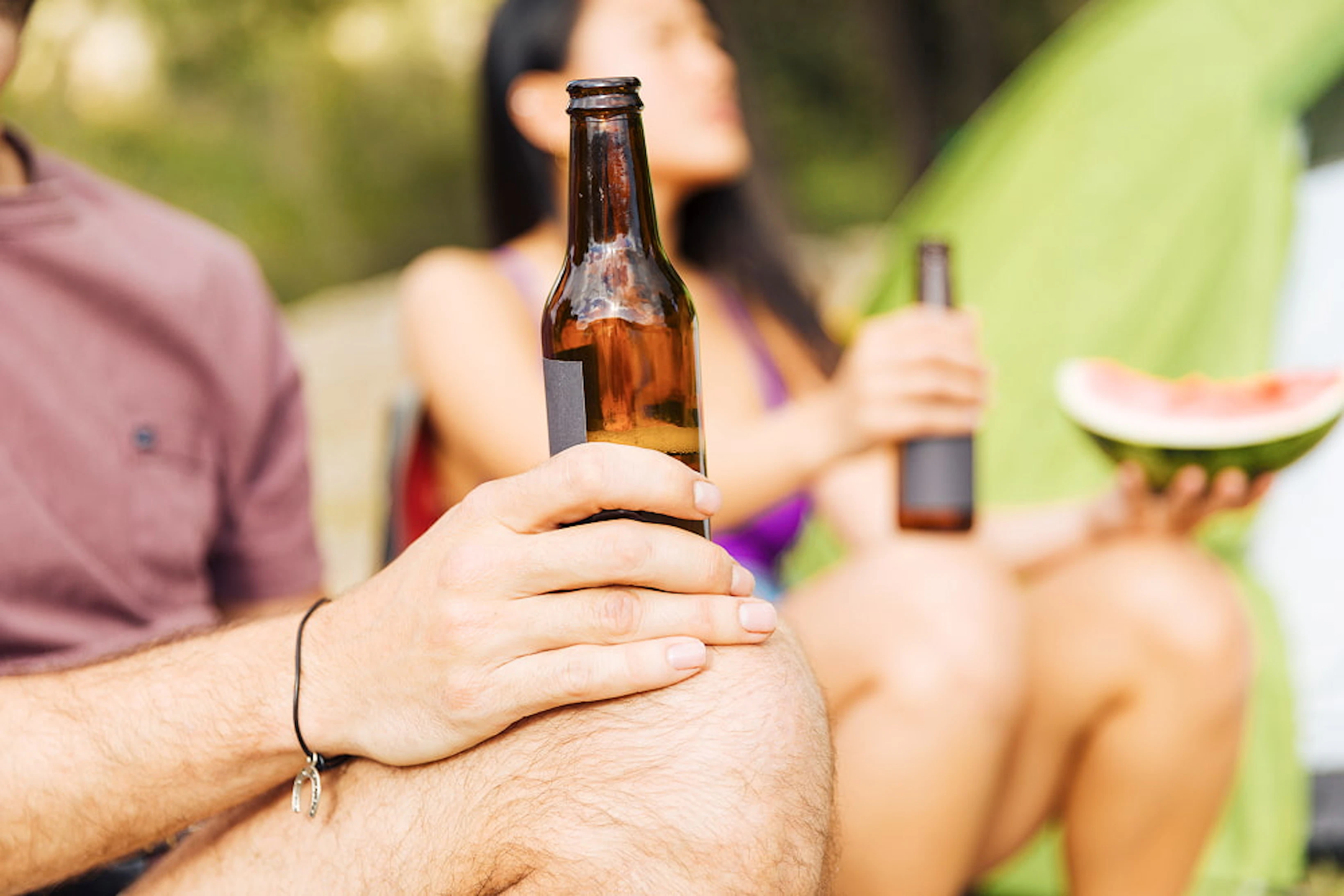 homme assis tient biere