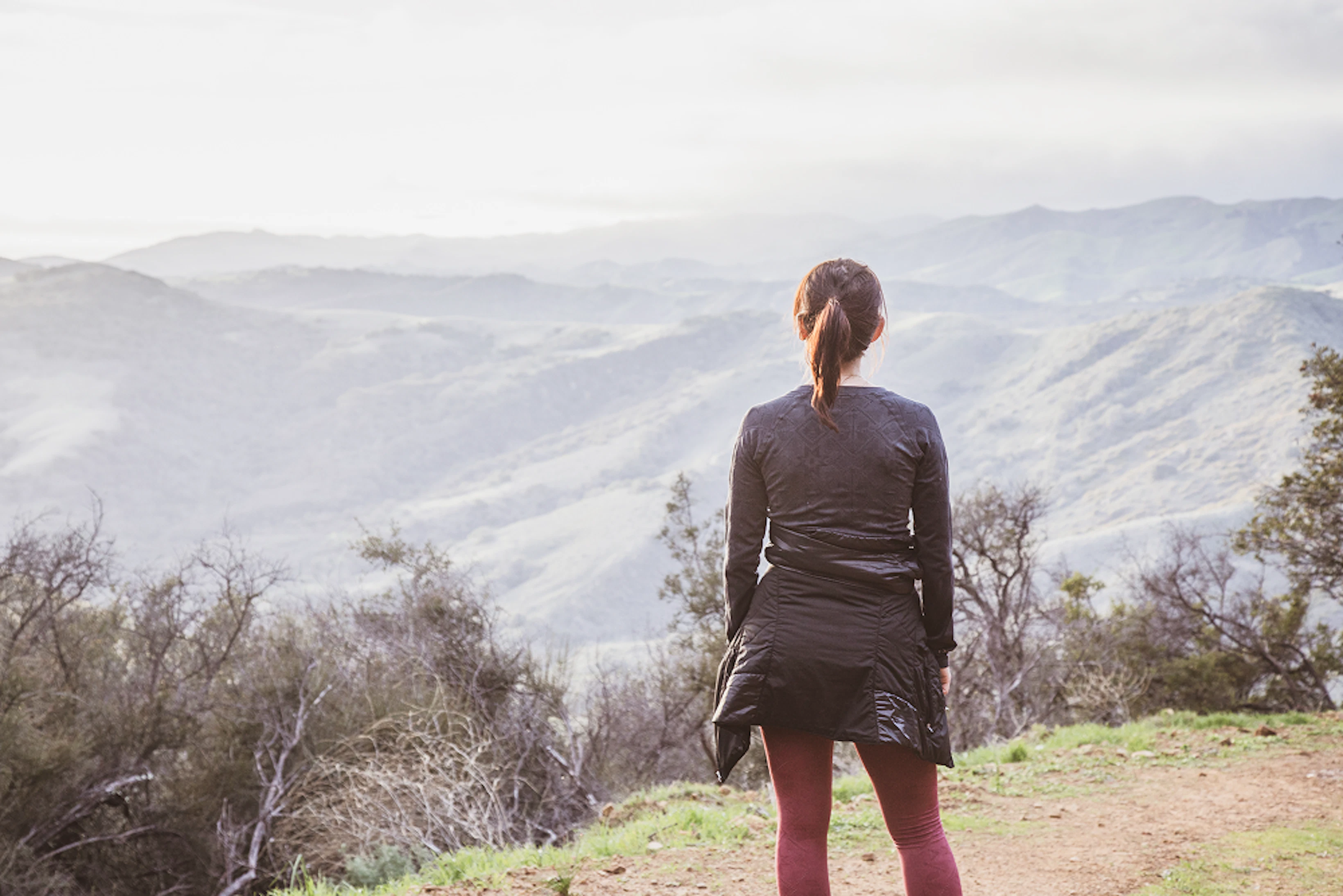 Une femme admire un paysage montagneux.