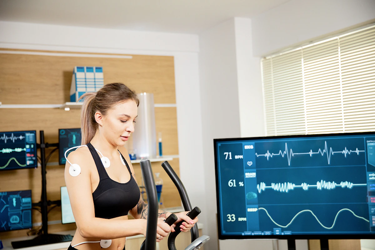 Une femme s'apprête à réaliser un test d'effort. Des électrodes sont branchés sur son corps.