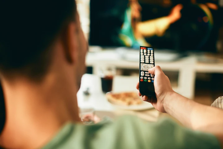 Un homme regarde la télévision.