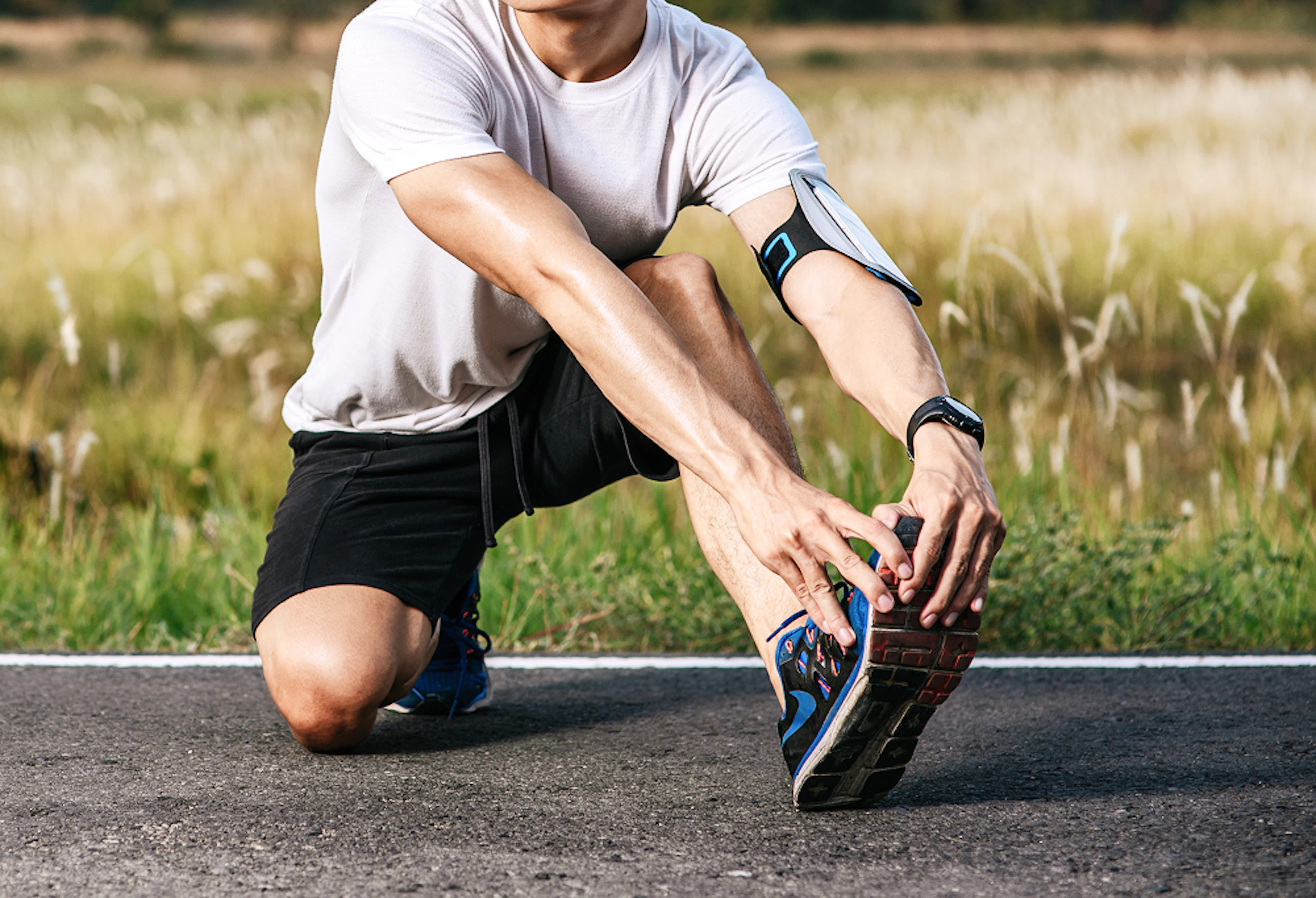 Un homme en tenue de course à pied se tient l'avant du pied.
