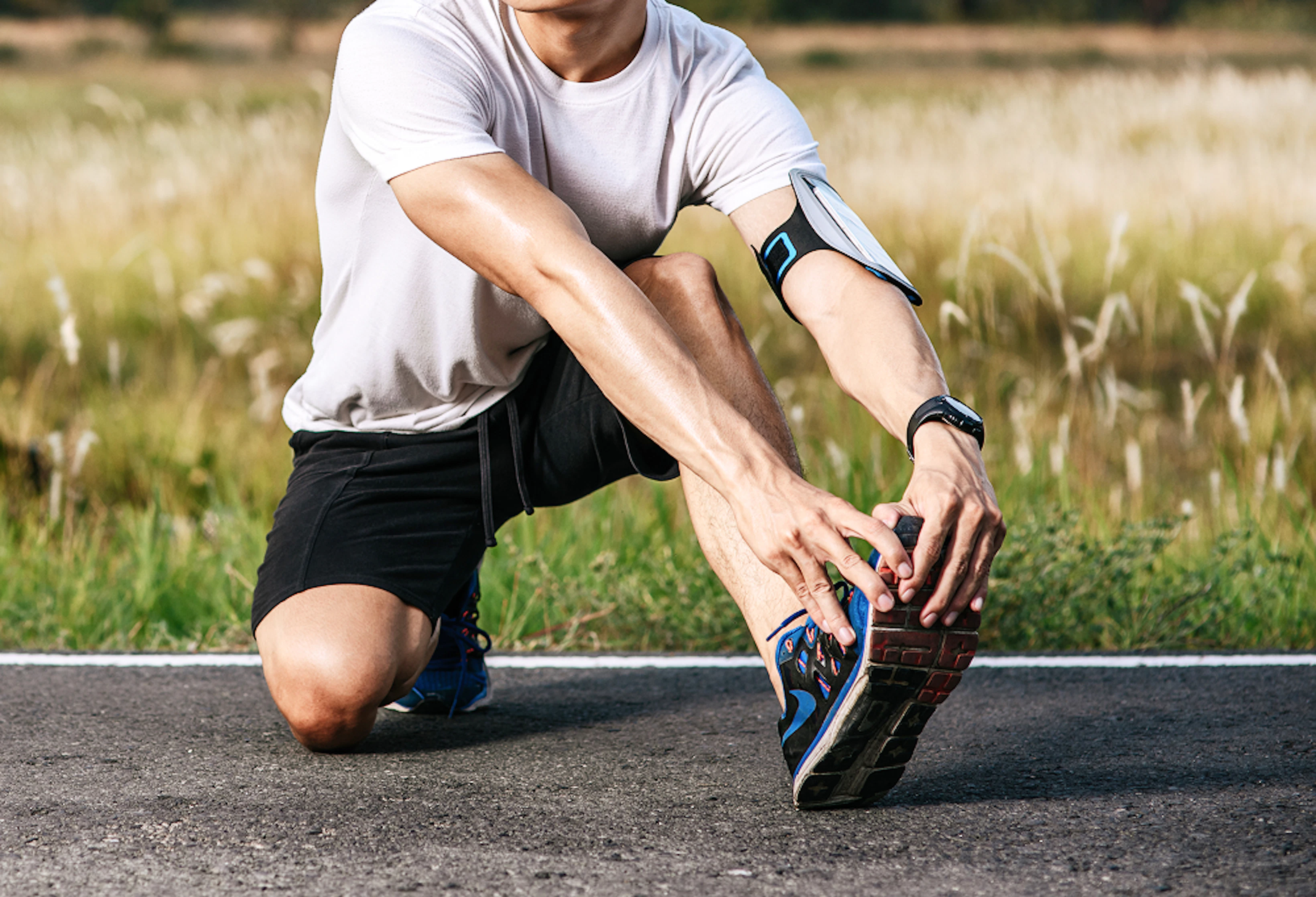 Un homme en tenue de course à pied se tient l'avant du pied.