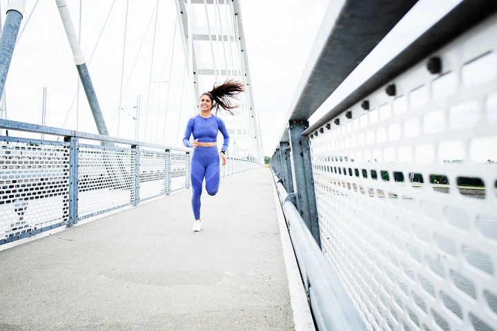 Une femme court sur une passerelle.