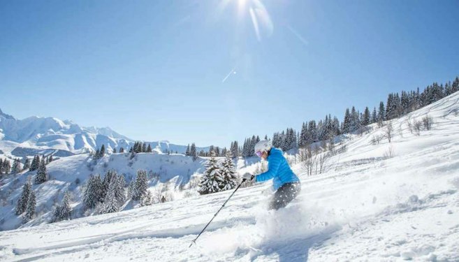 Forfait ski Combloux pas cher | Passe Montagne Skieur en descente sur une piste ensoleillée de Combloux en Haute-Savoie