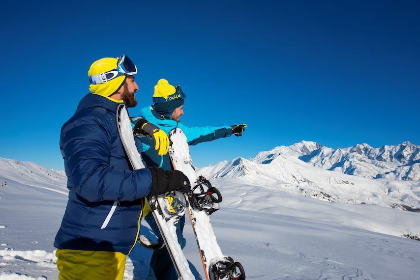 Snowboardeurs observant les sommets enneigés depuis Crest-Voland Cohennoz en Savoie