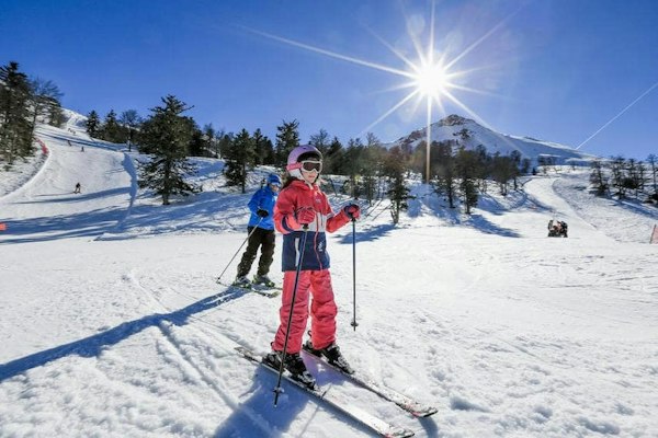 Skieurs à contre-jour sur les pistes ensoleillées de Hautacam dans les Hautes-Pyrénées