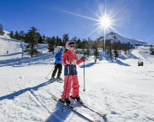 Forfait ski Hautacam pas cher | Passe Montagne Skieurs à contre-jour sur les pistes ensoleillées de Hautacam dans les Hautes-Pyrénées