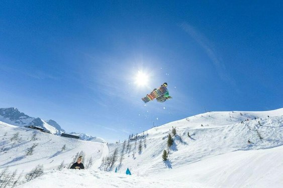 Snowboardeur en plein saut dans le snowpark d'Isola 2000 dans les Alpes-Maritimes