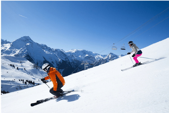 Forfait ski La Plagne pas cher | Passe Montagne Deux skieurs en descente sur une piste de La Plagne face aux sommets de Savoie
