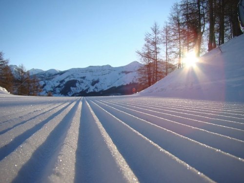 Forfait ski Le Seignus pas cher | Passe Montagne Piste fraîchement damée du Seignus au lever du soleil dans les Alpes-de-Haute-Provence