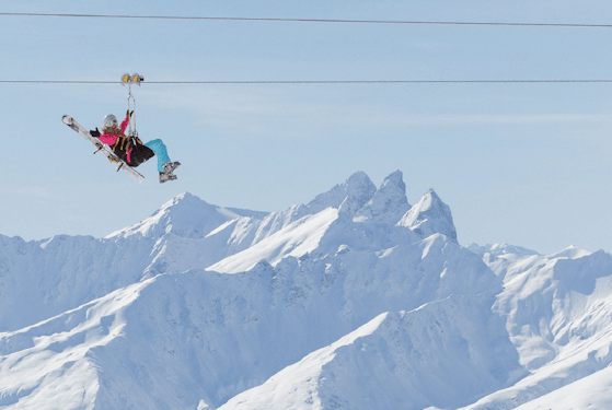 Les 3 Vallées cheap ski pass | Passe Montagne Snowboarders mid-air above the peaks of Les 3 Vallées, Savoie