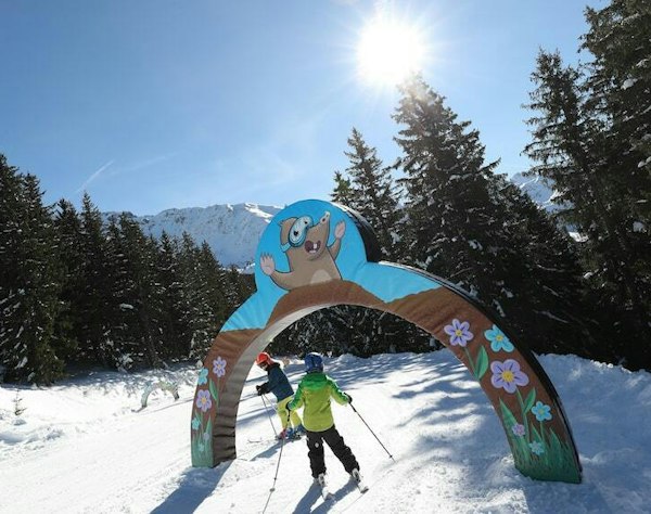 Forfait ski Les 7 Laux pas cher | Passe Montagne Enfant à ski sous l’arche de la zone ludique des 7 Laux en Isère