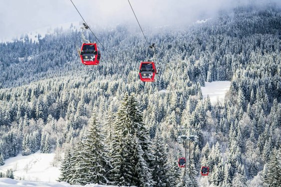 Cabines de télécabine des Gets au-dessus de la forêt enneigée en Haute-Savoie