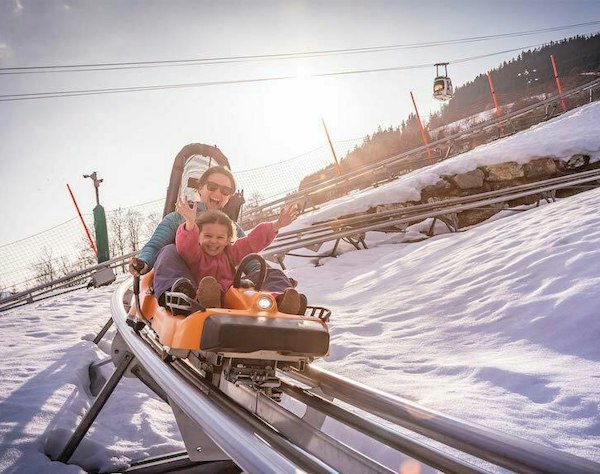 Megève cheap ski pass | Passe Montagne Family riding the rail sledge at Megève, Haute-Savoie
