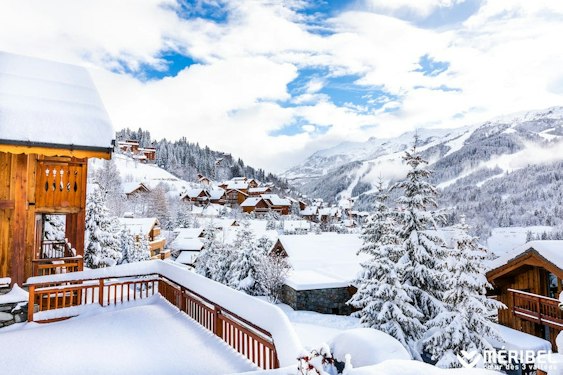 Méribel cheap ski pass | Passe Montagne Snow-covered chalets at Méribel seen from a wooden balcony, Savoie