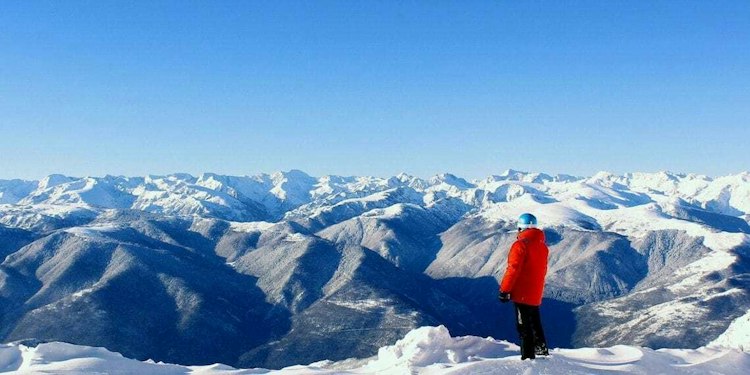 Skier facing the Ariège peaks from Monts d'Olmes