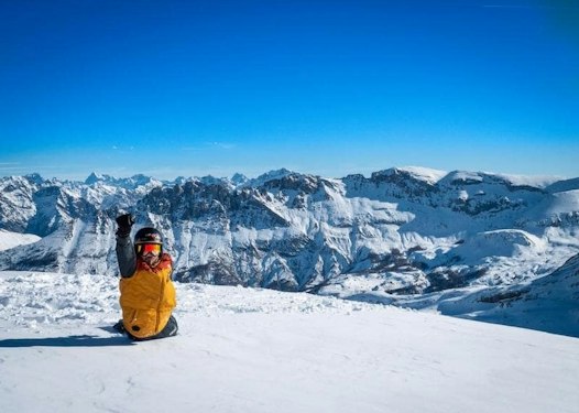 SuperDévoluy cheap ski pass | Passe Montagne Skier facing the snowy SuperDévoluy peaks, Hautes-Alpes