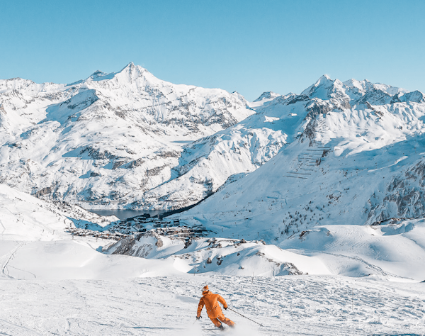 Tignes cheap ski pass | Passe Montagne Skier facing the snowy Tignes peaks, Savoie