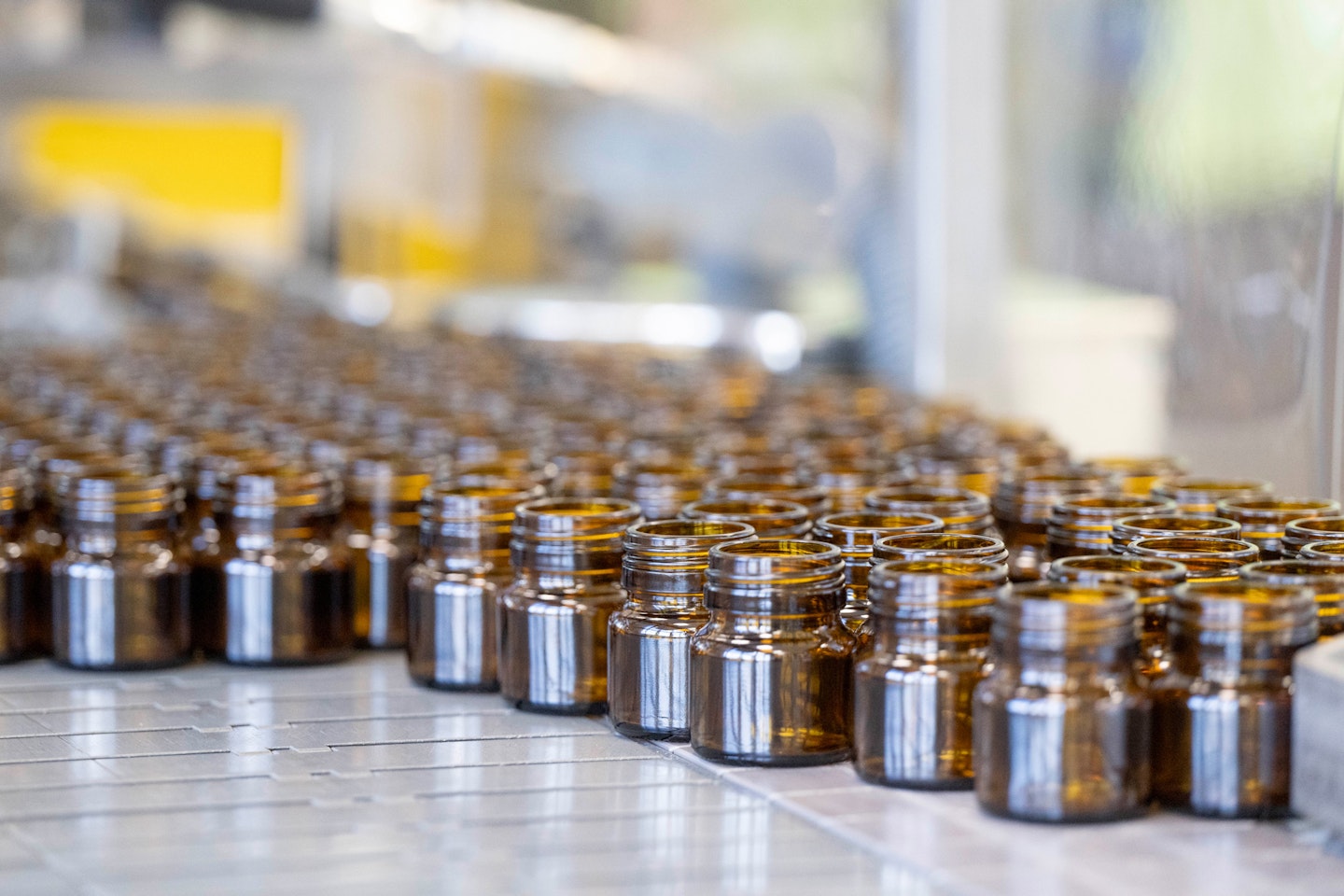 Braune Glasflaschen auf einer Abfülllinie in der Produktion – wiederverwendbare Verpackung zum Schutz sensibler Inhalte