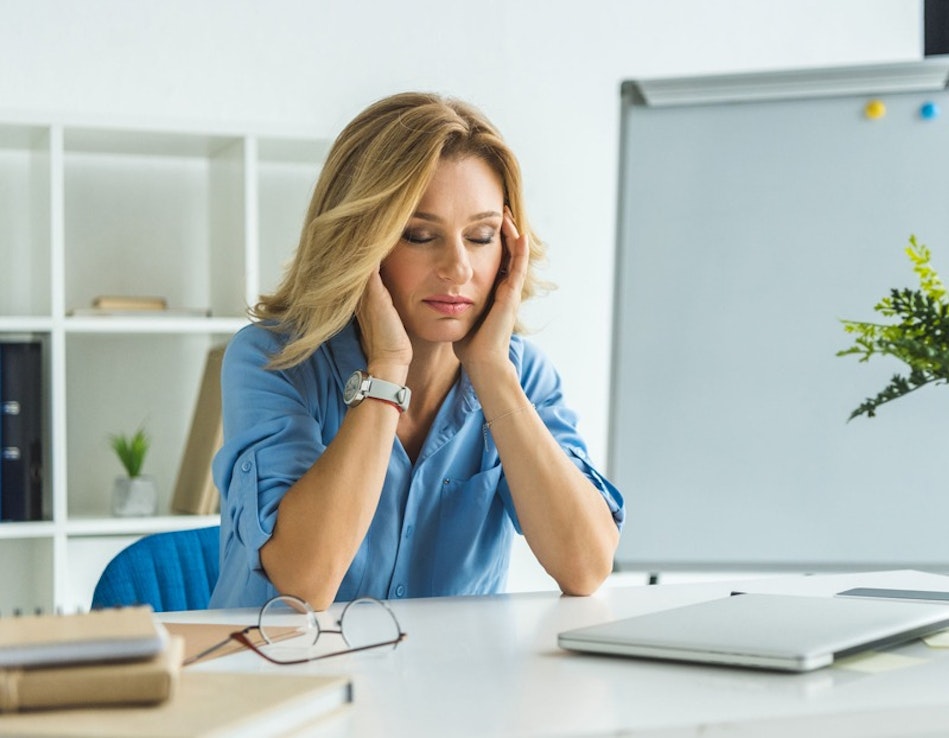 Frau gestresst am Arbeitsplatz