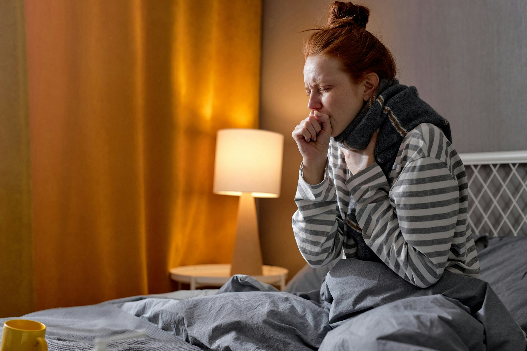 Reizhusten Frau hustend im Bett