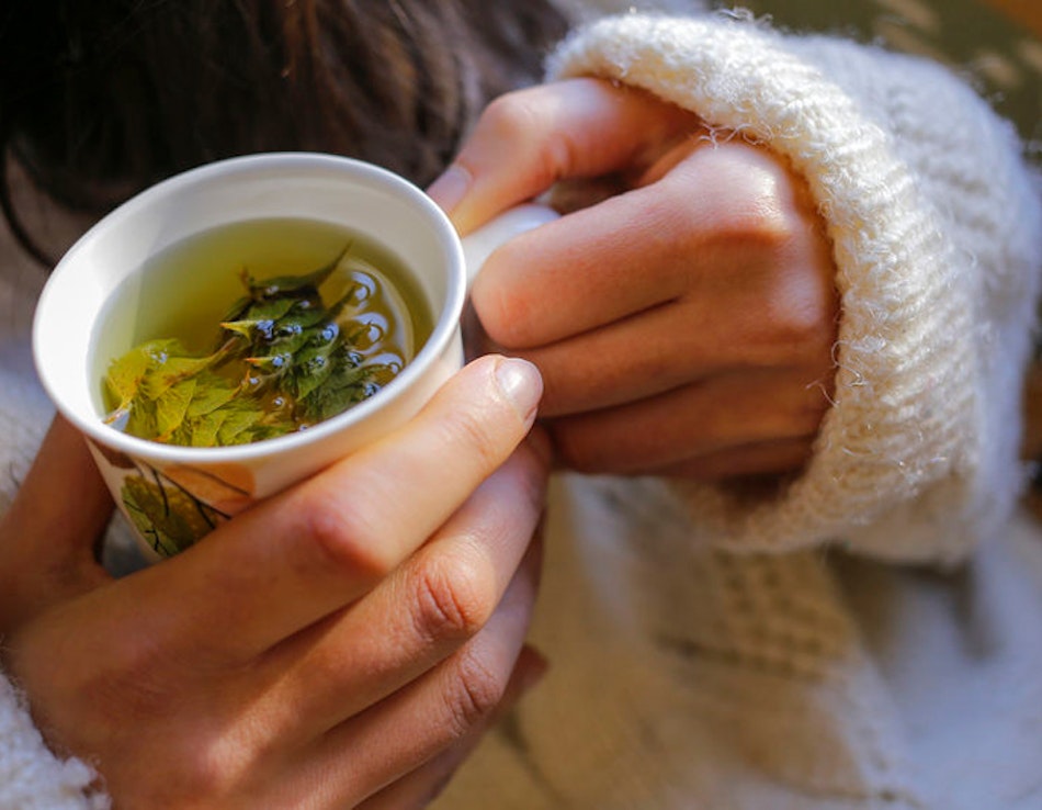 Gurgeln mit Kräutersee Frau hält Tasse mit Salbeitee