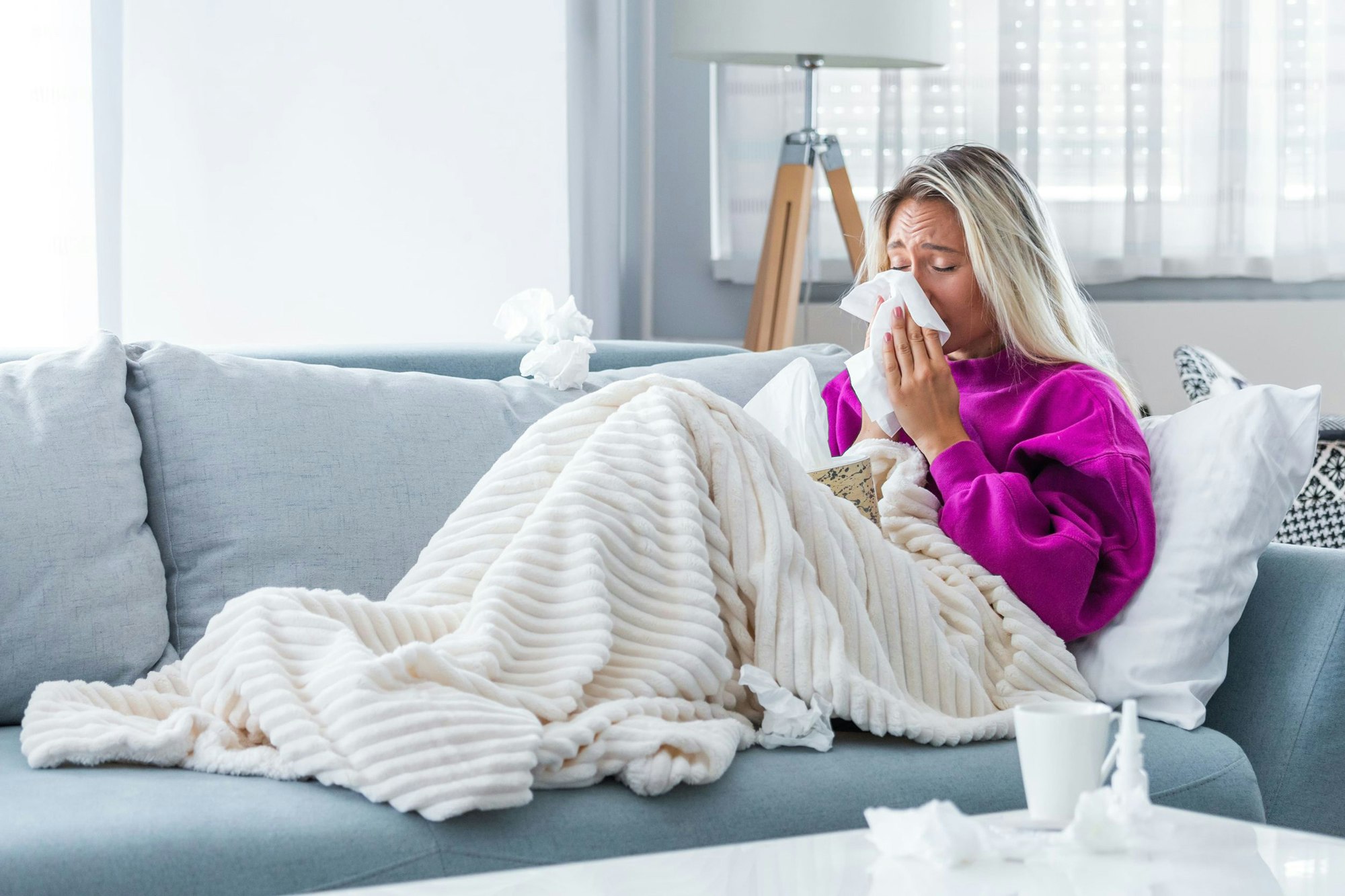 Schnupfen Frau mit Schnupfen auf dem Sofa