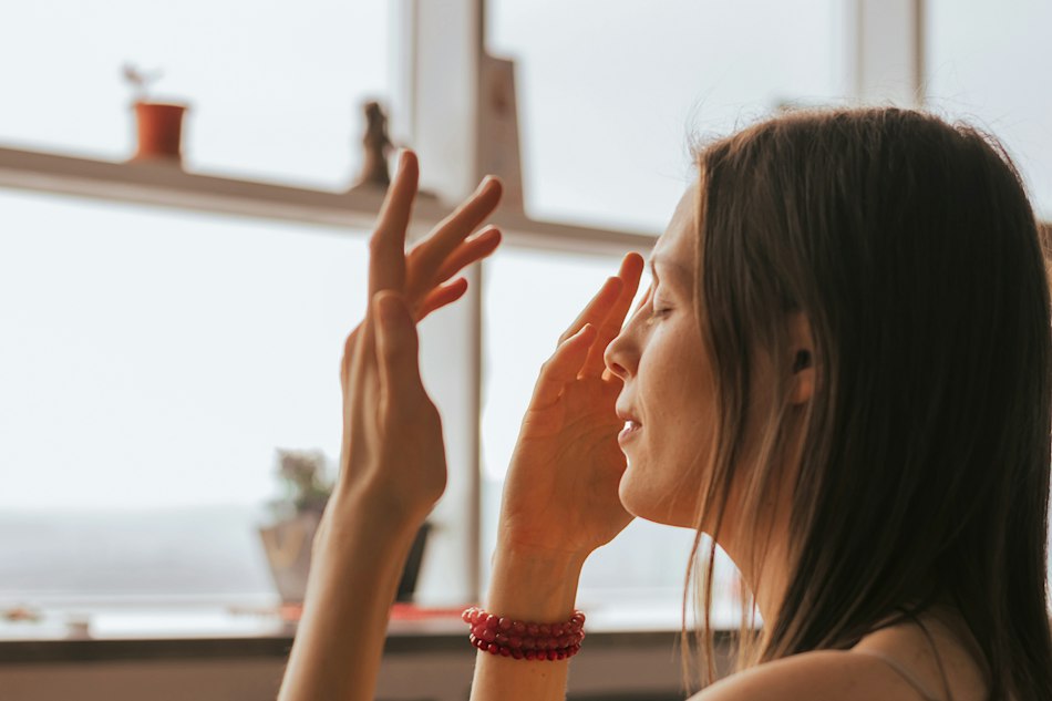 Frau macht Augen-Übungen am Fenster
