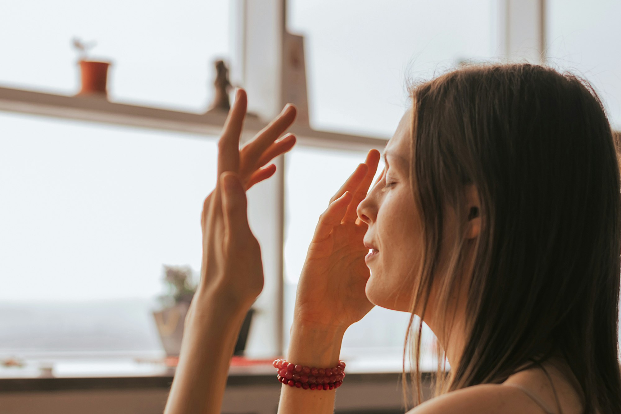 Frau macht Augen-Übungen am Fenster