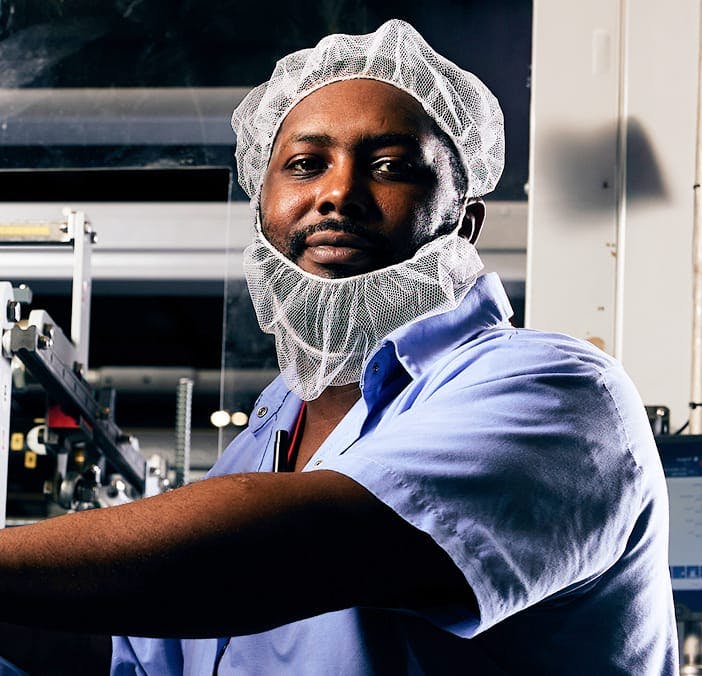Matrix Bottling Group employee in blue collared shirt and mesh hairnet