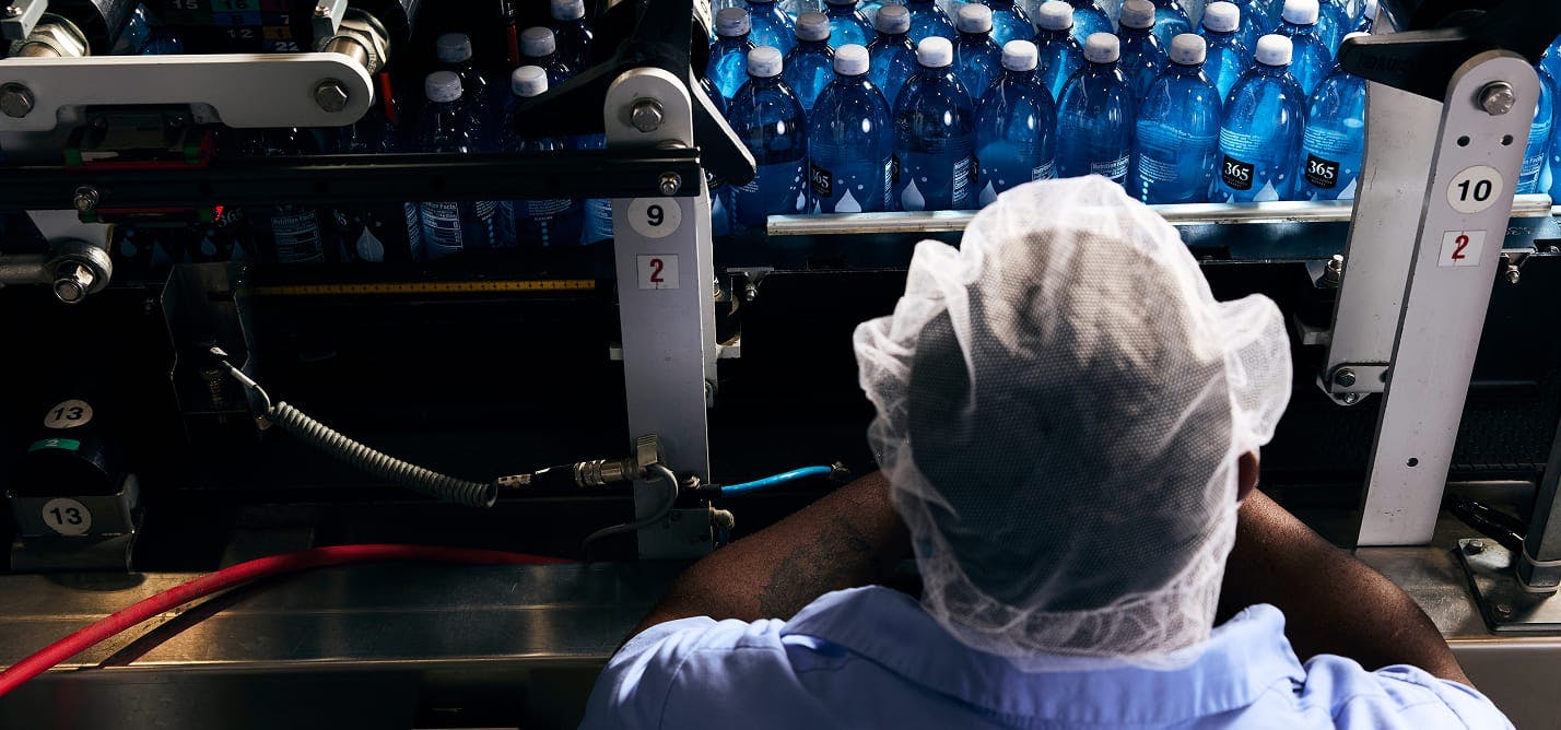 Matrix Bottling Group employee operating belt of machinery carrying bottles