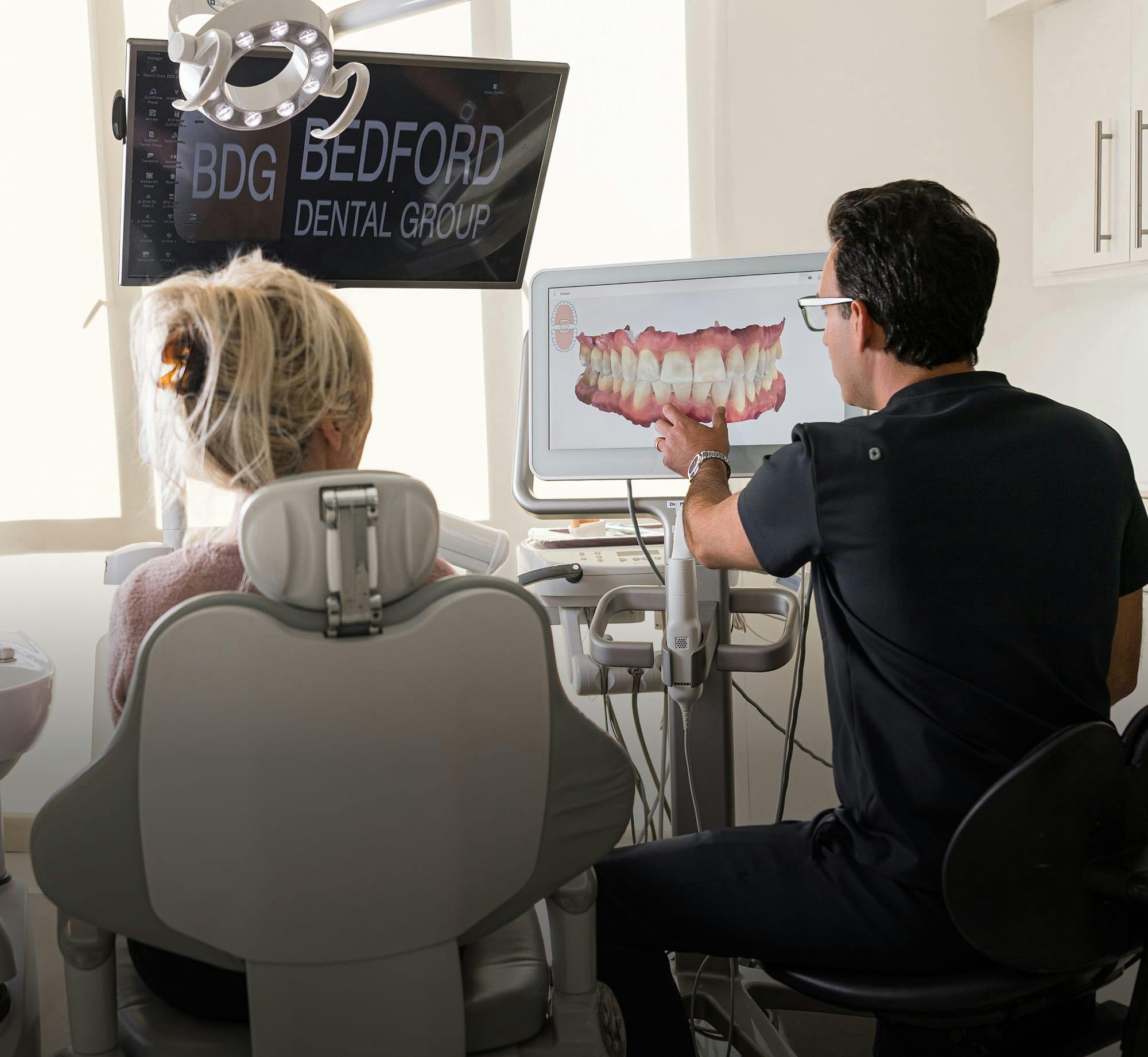 dentist and patient looking at a photo of teeth