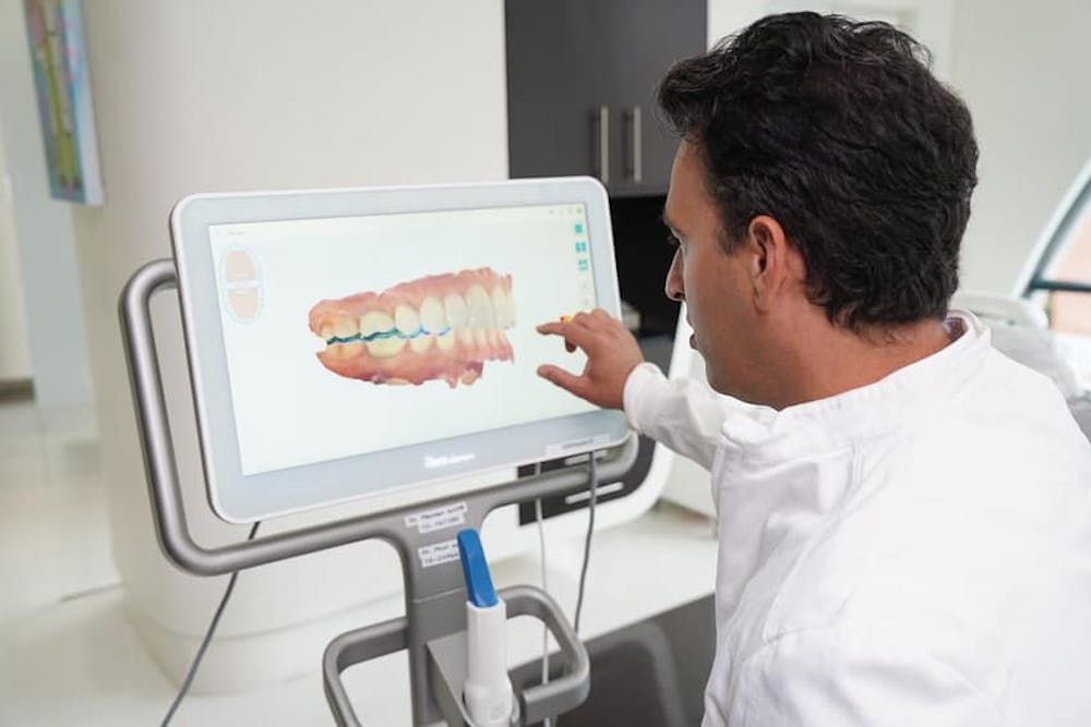 Photo of Dr. Daniel Naysan examining a 3D scan of teeth
