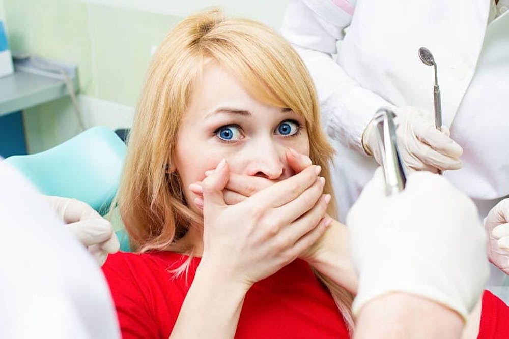 dental patient covering their mouth