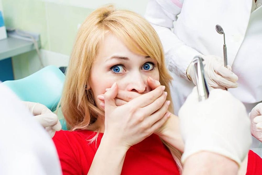 dental patient covering their mouth