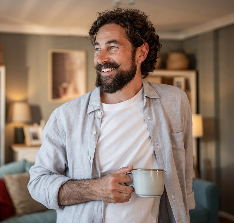 man smiling with a mug in his hand