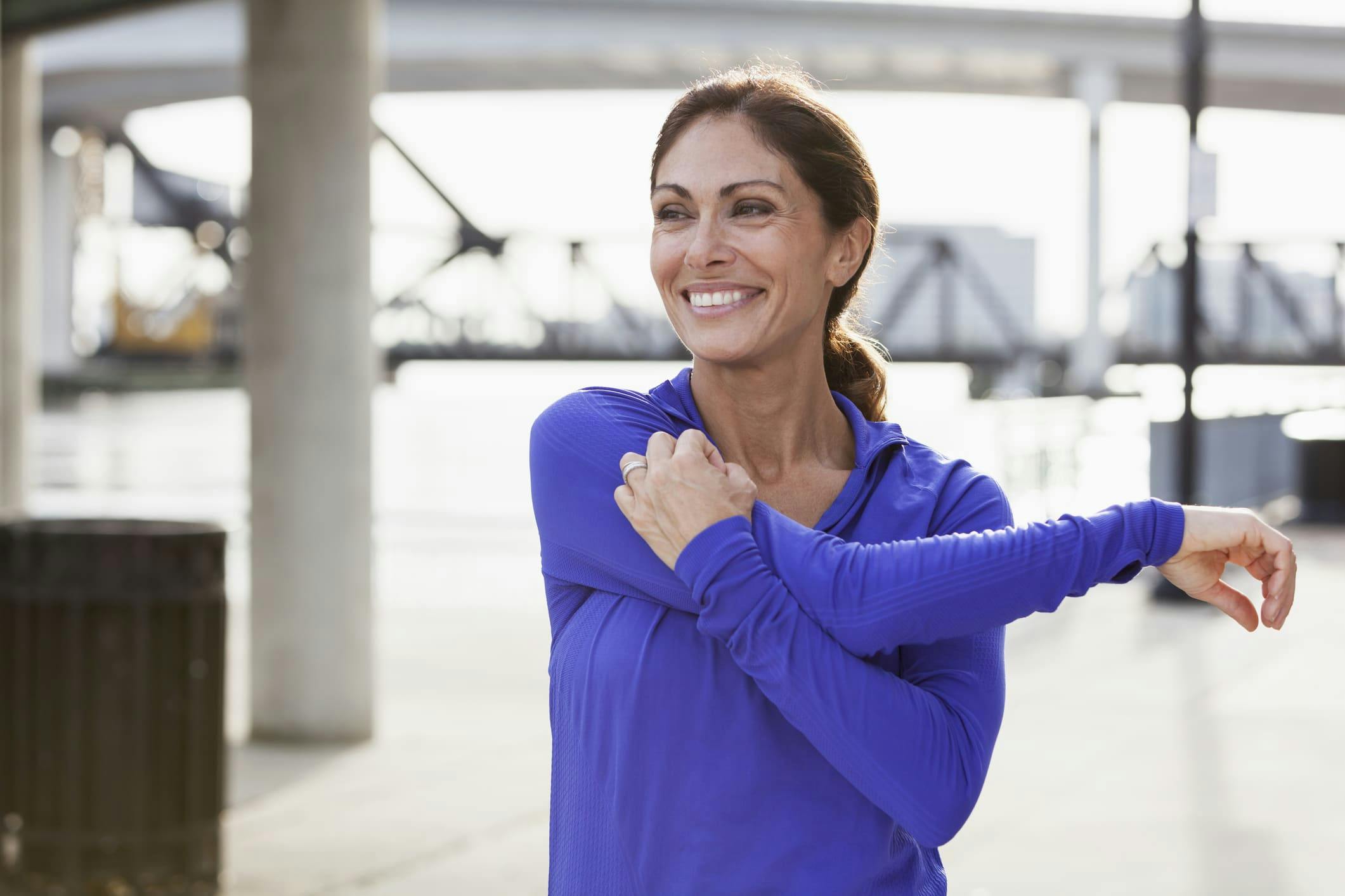 woman smiling and stretching her arm