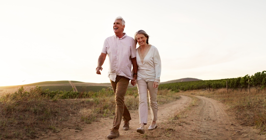 couple holding hands and walking on path together