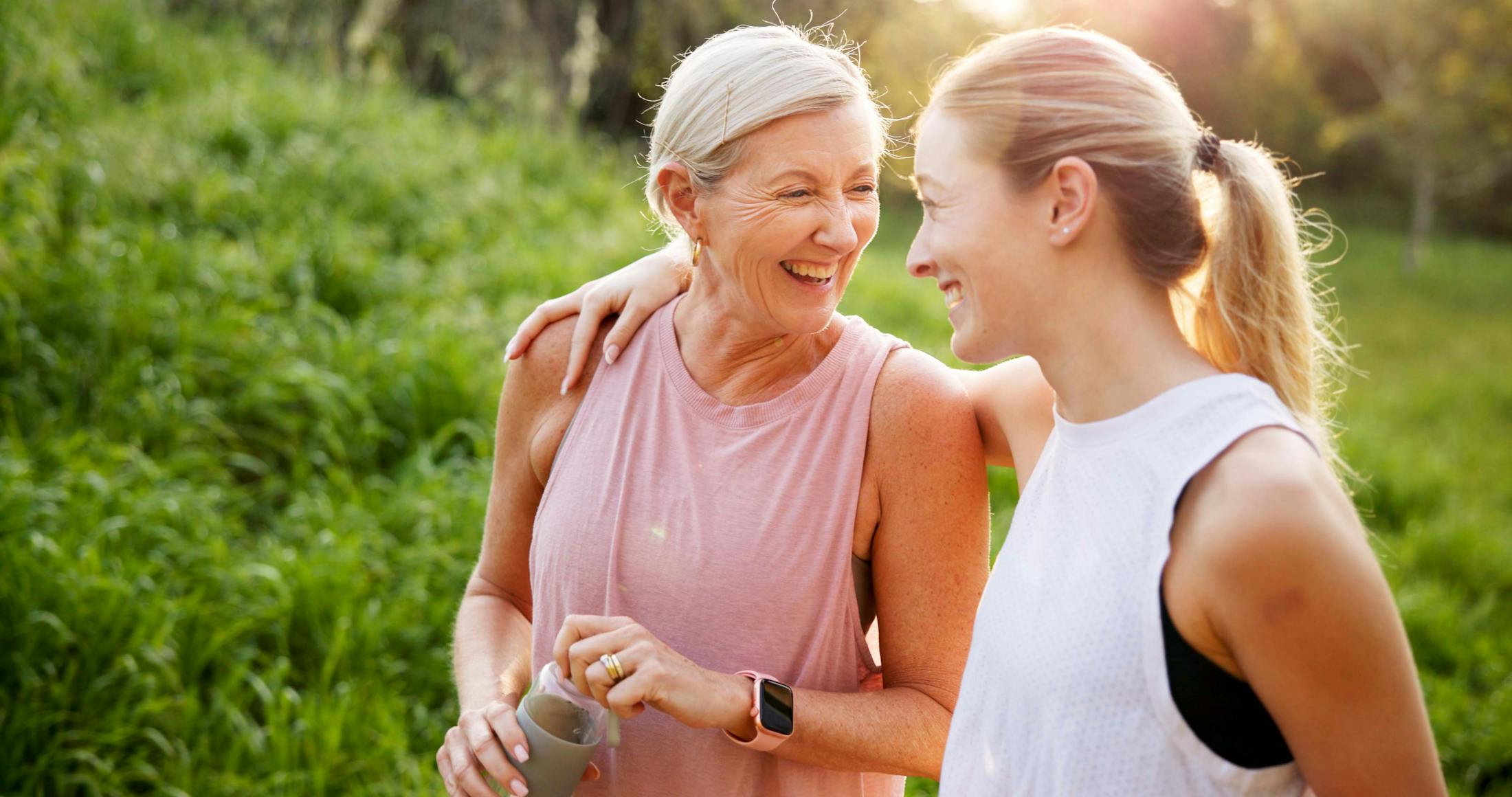 2 women smiling with eachother while on a walk