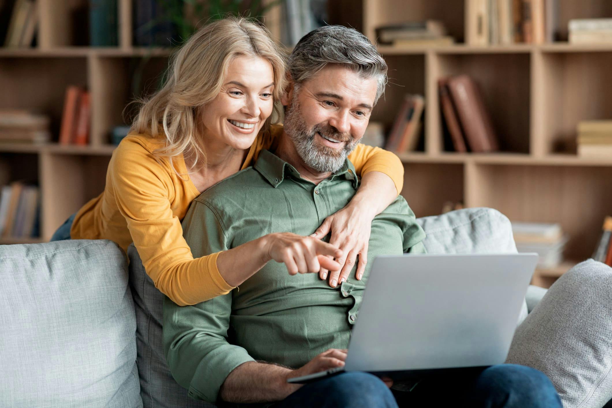couple looking at laptop together on the couch