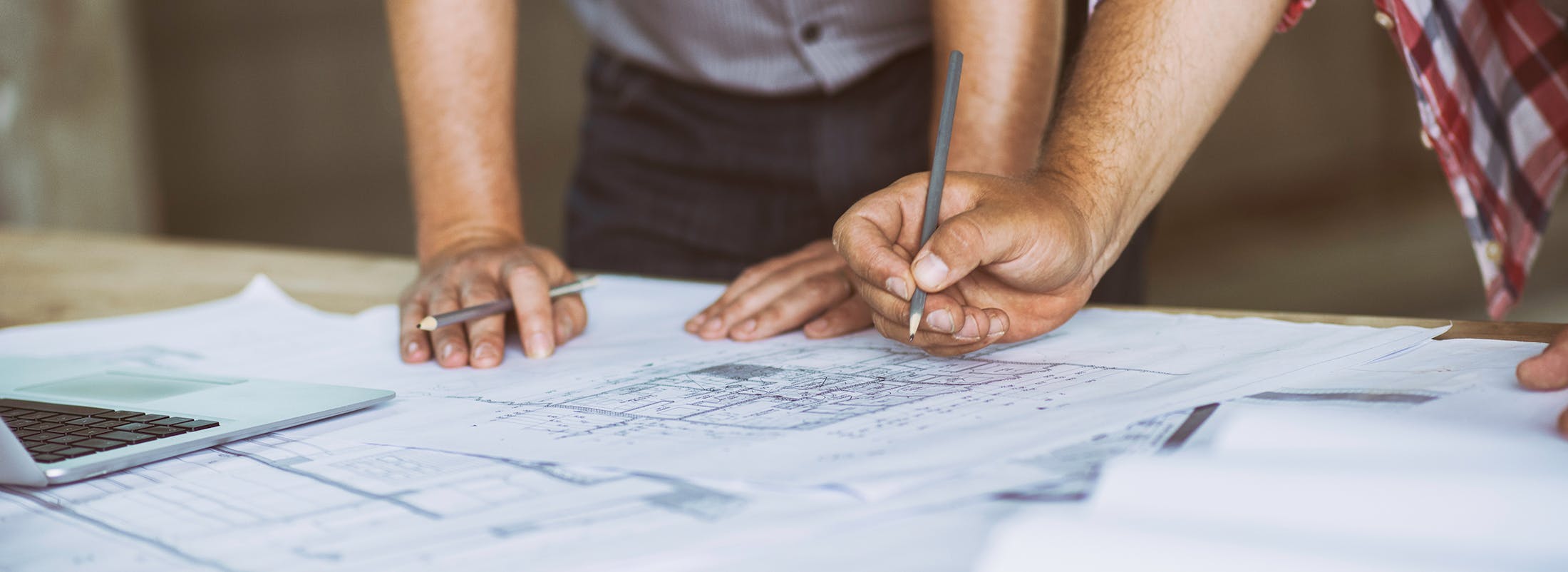 Two people working on paper floor plan