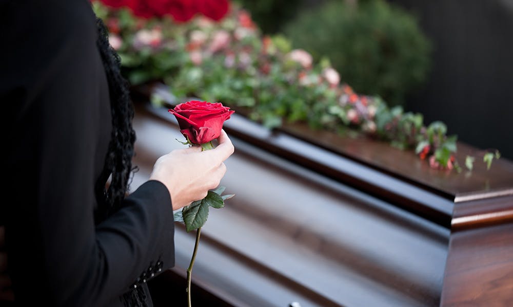 Person holding flower at funeral