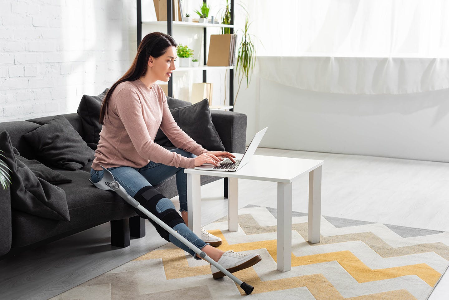 Injured woman looking at a laptop