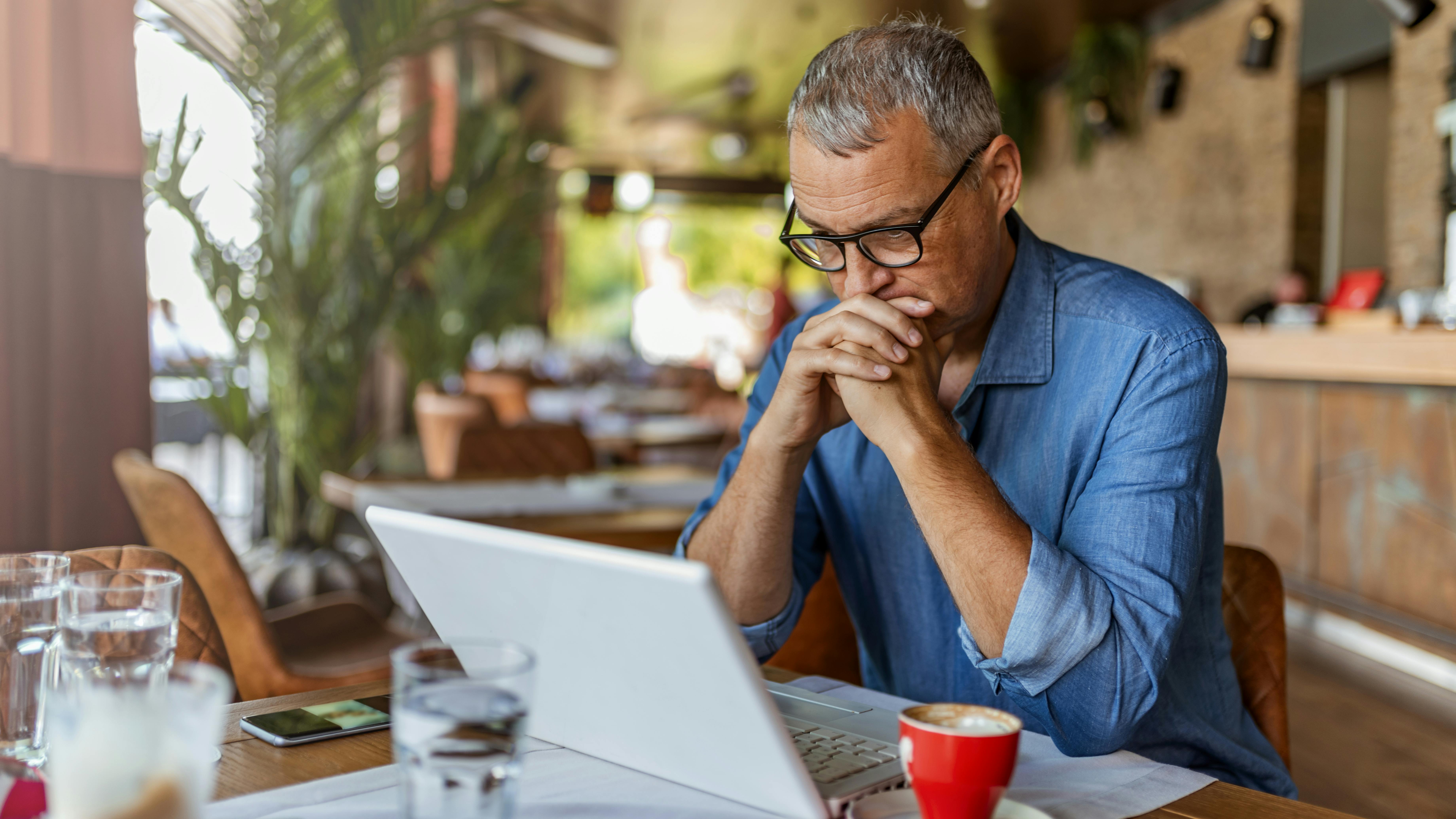 Man at table looking at laptop