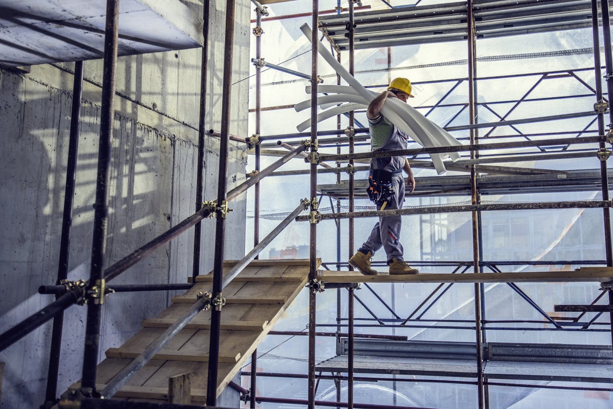 Man on scaffolding carrying items