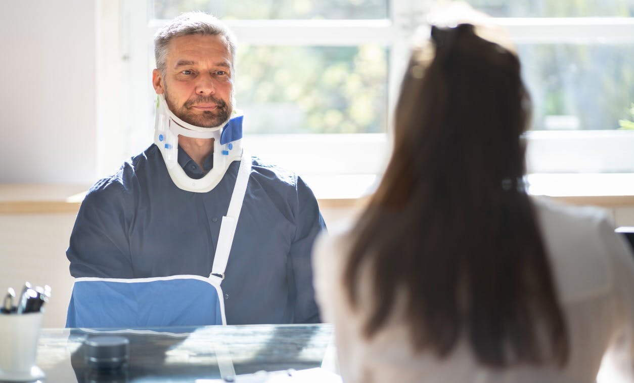 Injured man sitting at desk